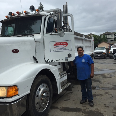 Able Paving truck and crew member on a job site